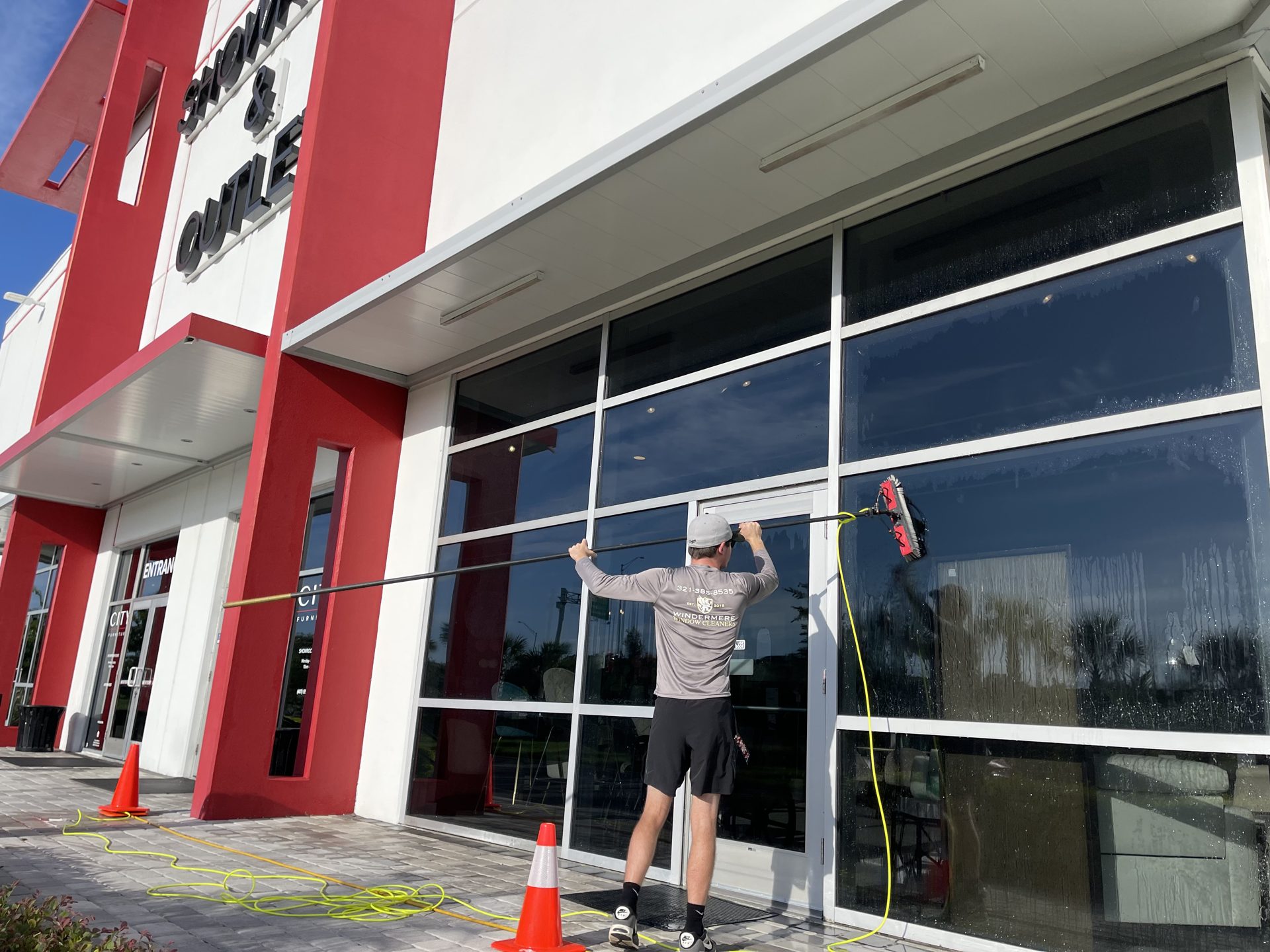 Technician cleaning the glass of a retail storefront