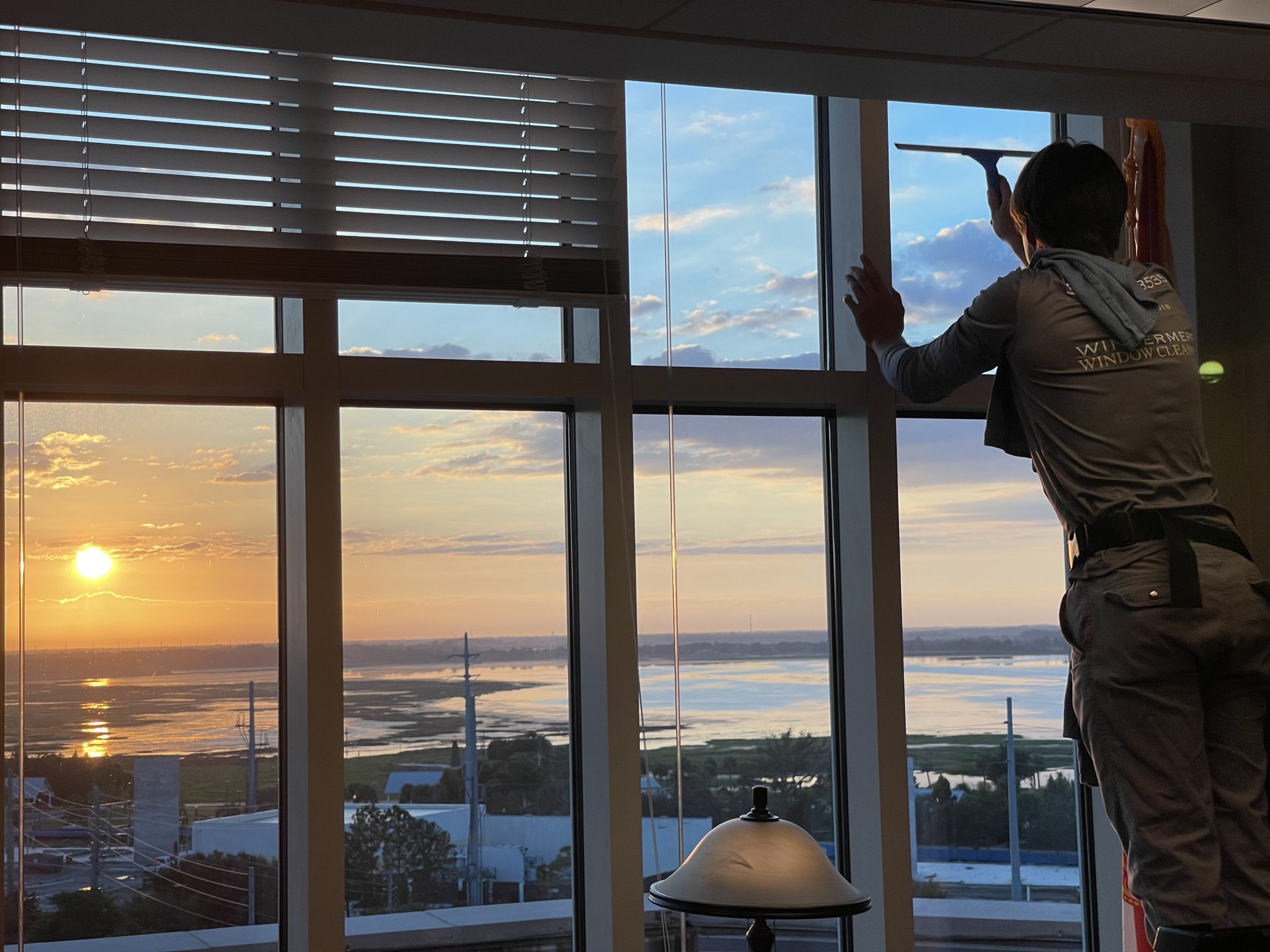 Sunset over the water seen through tall interior windows after cleaning