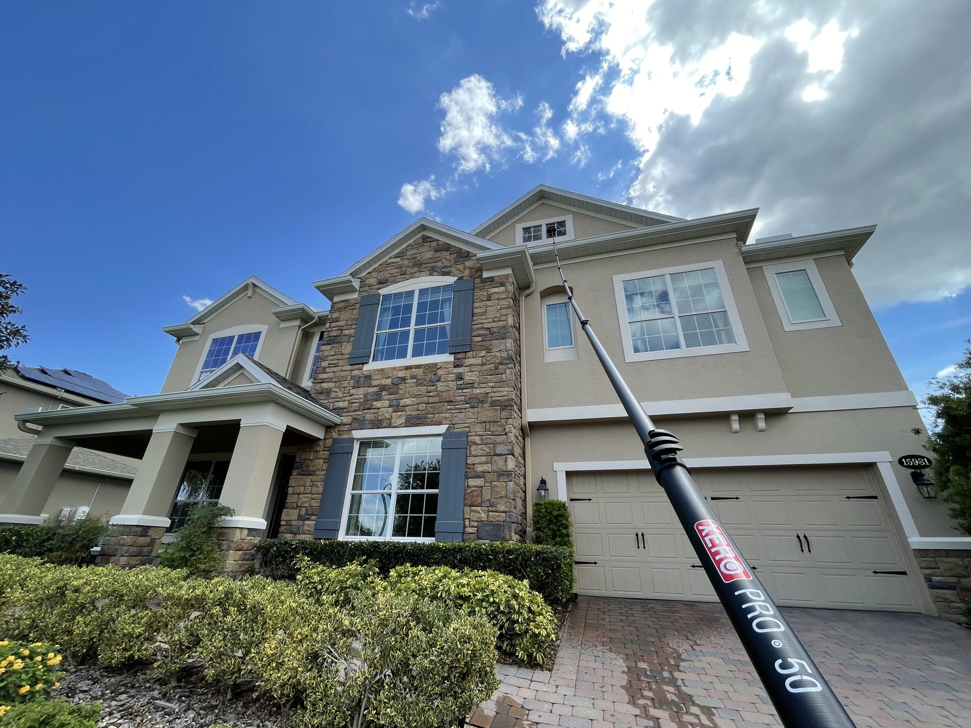 Cleaning a second-story dormer window with a water-fed pole
