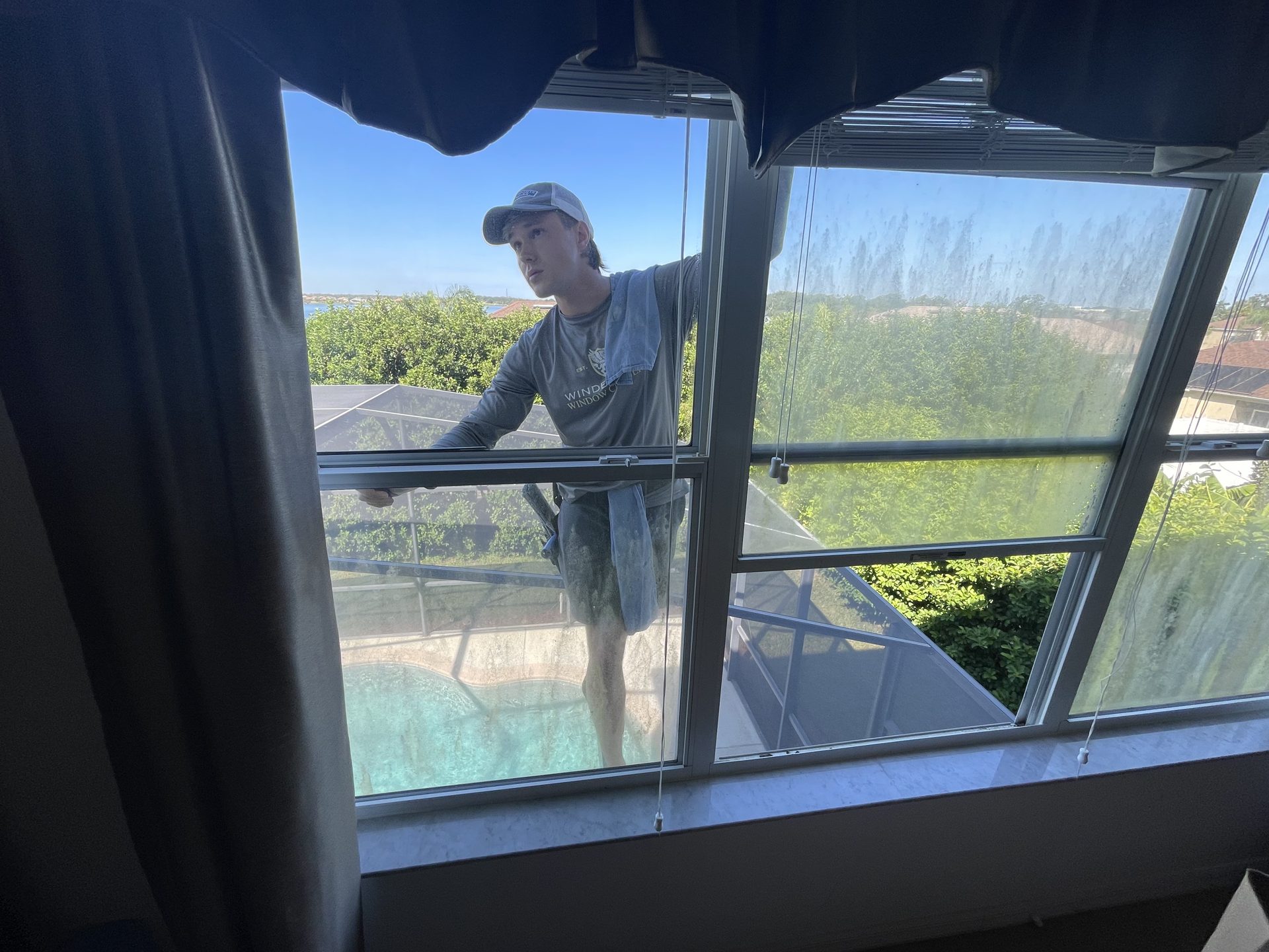Cleaning the glass panels of a home's lanai and pool enclosure