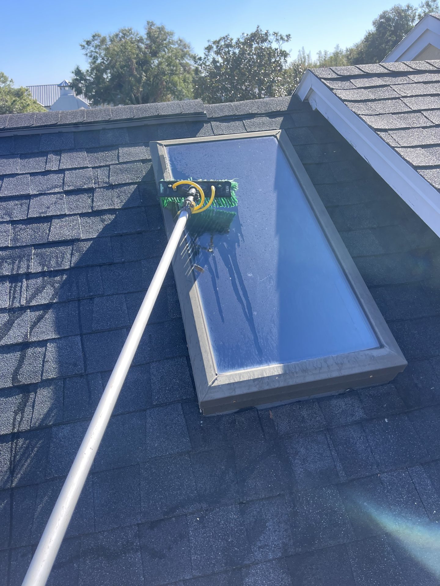 Cleaning a roof skylight with a water-fed pole brush