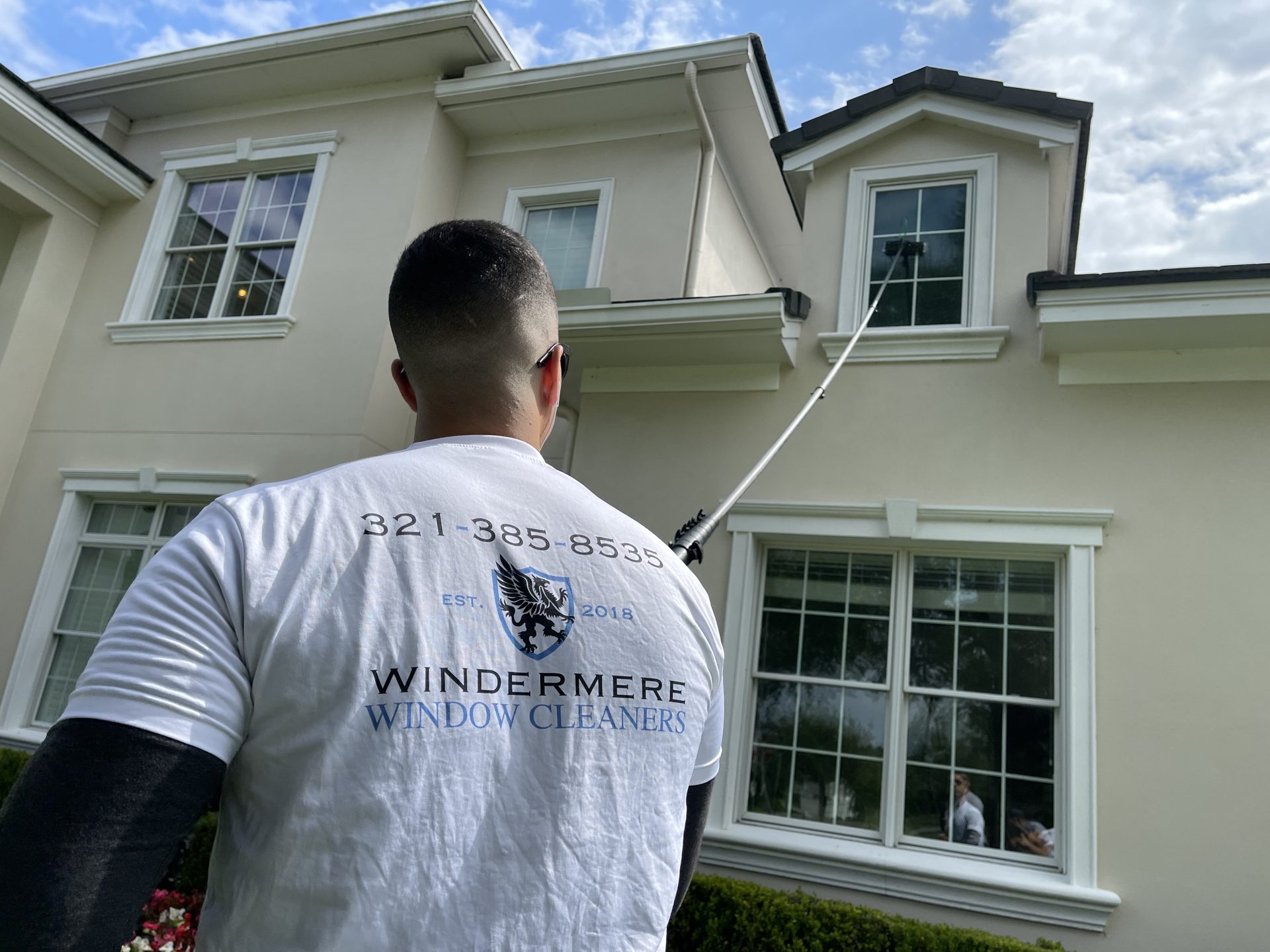 Windermere Window Cleaners technician cleaning second-story windows