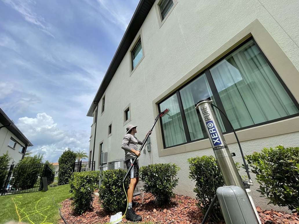 Pure-water pole cleaning system set up outside a home during an exterior clean